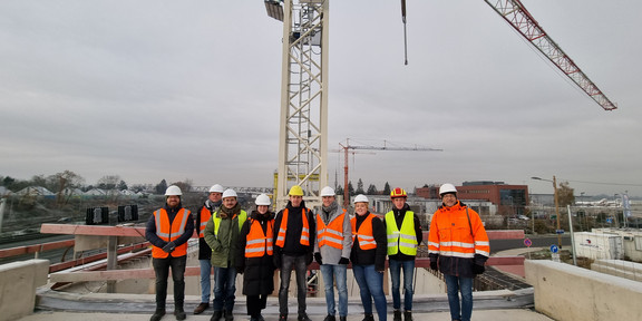 Exkursionsteilnehmer:innen vor der Baustelle der U-Bahn Linie U81 